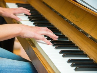 En person spelar på ett piano.