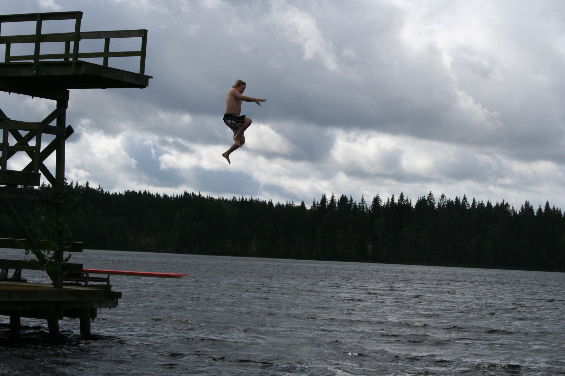 En kille hoppar från ett hopptorn i vattnet
