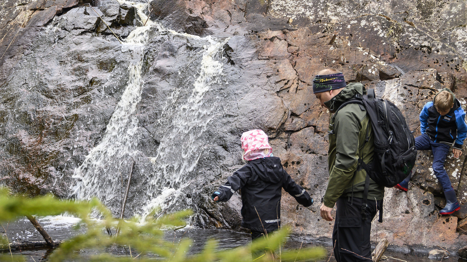 En familj tittar på vattenfallet i naturreservatet Hatten.