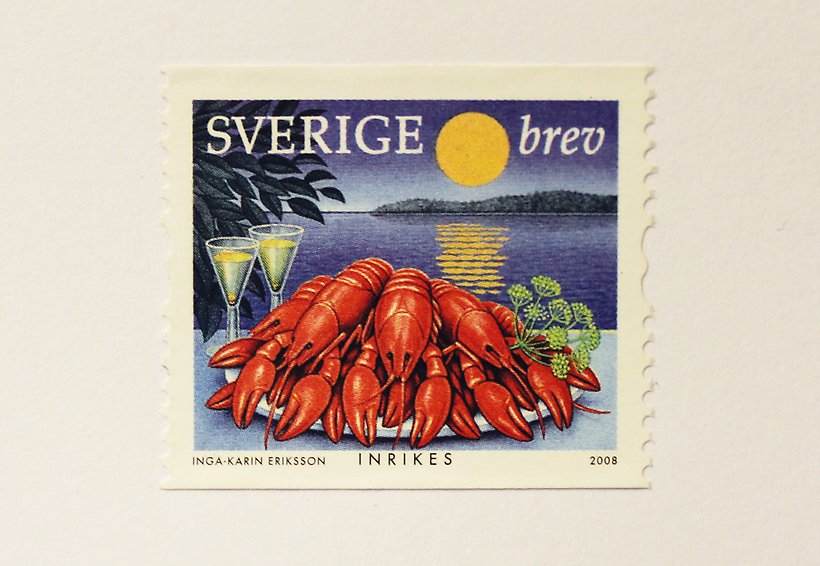 Ett frimärke med en talrik med kräftor vid en sjö på kvällen